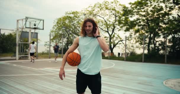 Кучерявий Рудий Чоловік Світло Зеленій Футболці Баскетболом Руках Позує Тлі — стокове відео