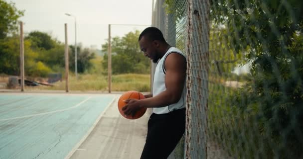 Giovane Uomo Colore Con Una Maglietta Bianca Tiene Mano Pallone — Video Stock