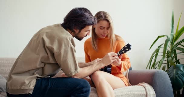 Ein Blondes Mädchen Lernt Gerade Gitarre Spielen Ein Brünetter Typ — Stockvideo