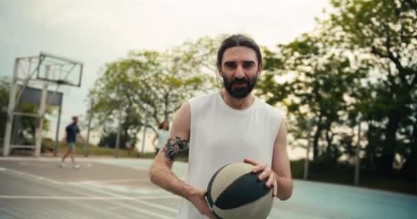 Muž Středního Věku Bílém Tričku Vousy Pózuje Pozadí Basketbalového Hřiště — Stock video