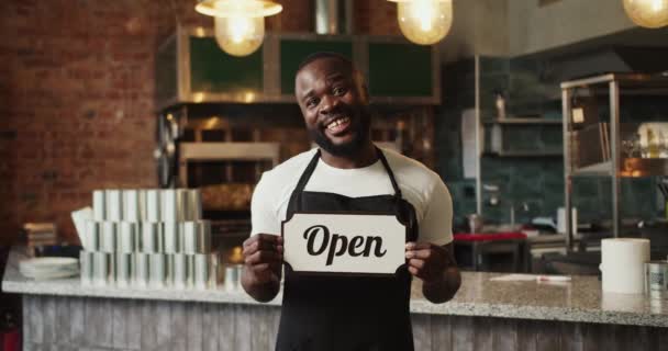Czarna Osoba Czarnym Fartuchu Trzyma Rękach Znak Otwarty Facet Uśmiecha — Wideo stockowe