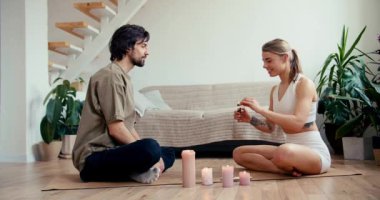 Çift, güneş odasında özel mumlar ve tütsüyle birlikte meditasyon yapıyor. Yüksek kalitede çekilen video.