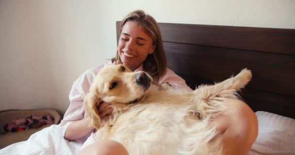 Beyaz Gecelikli Sarışın Bir Kız Köpeğine Sarılıyor Açık Renkli Yatakta — Stok video