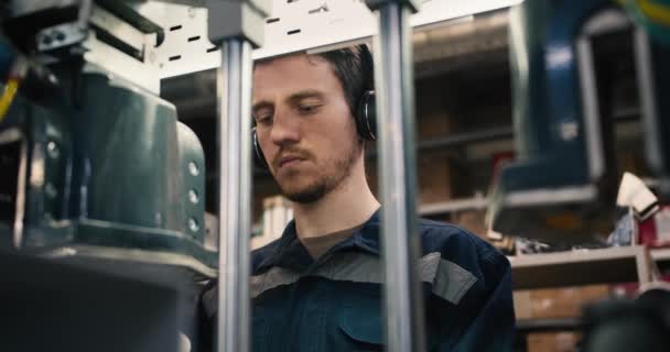 Primer Plano Hombre Pelirrojo Poniéndose Auriculares Trabajando Una Máquina Industrial — Vídeo de stock