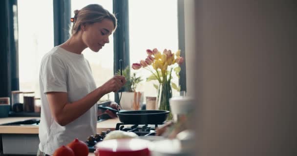 Una Chica Rubia Con Una Camiseta Blanca Cocina Desayuno Una — Vídeos de Stock