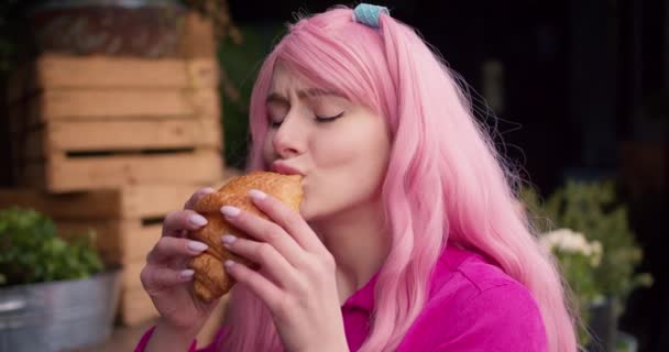 Close Uma Menina Com Cabelo Rosa Degustando Delicioso Croissant Café — Vídeo de Stock