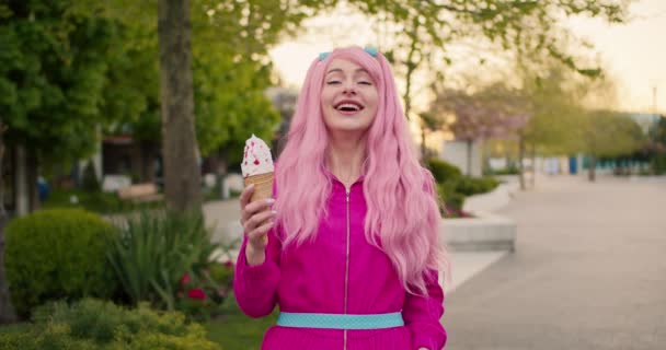 분홍색 머리와 분홍색 귀여운 소녀는 분홍색 아이스크림을 미소를 짓는다 거리의 — 비디오