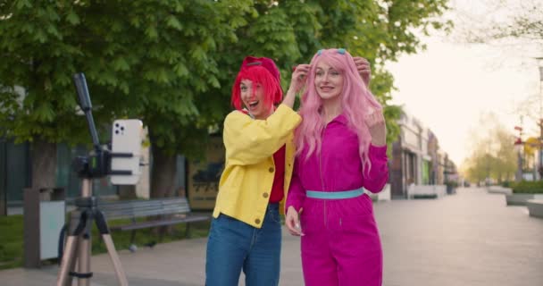 분홍색 머리의 소녀와 머리의 소녀는 거리에 자신의 외모에 비디오 블로그를 — 비디오