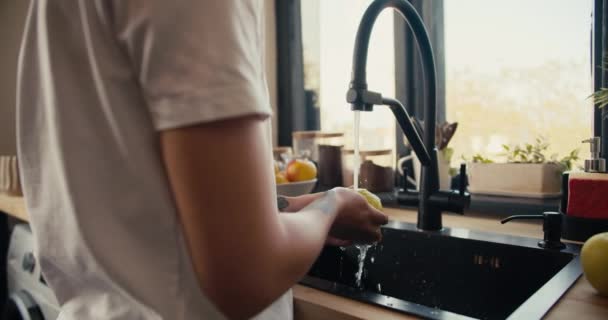 Beyaz Tişörtlü Bir Kızın Yakın Plan Fotoğrafı Mutfaktaki Lavaboda Meyve — Stok video