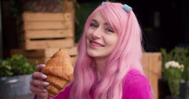 Portrét Šťastné Veselé Dívky Růžovými Vlasy Drží Načechraný Croissant Rukou — Stock video