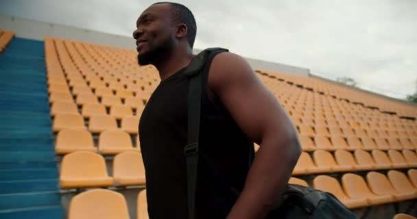 Siyah Tişörtlü Siyah Tenli Bir Sporcunun Tribünlerde Sarı Sandalyelerle Stadyumda — Stok video
