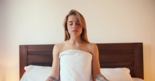 Porträtt Blond Flicka Som Sitter Med Slutna Ögon Sängen Mediterar — Stockvideo