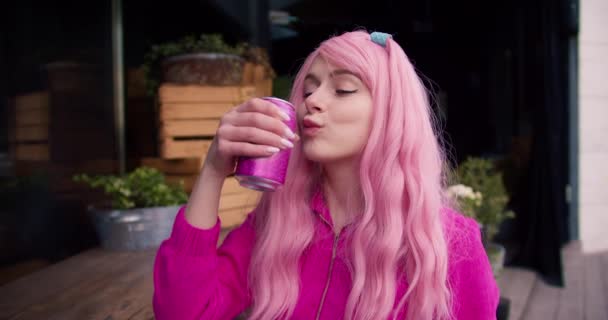 Een Meisje Roze Kleren Met Roze Haar Drinkt Frisdrank Uit — Stockvideo