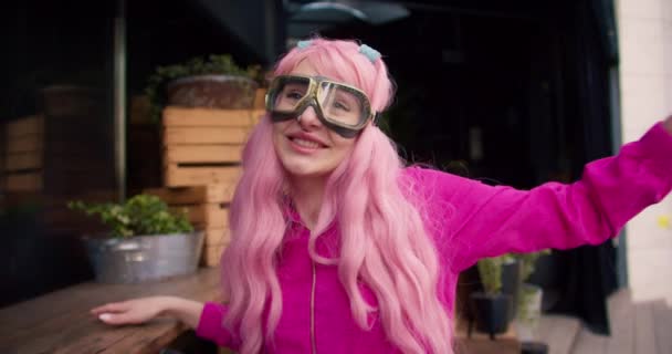 Ein Mädchen Pinkfarbener Kleidung Und Mit Pinkfarbenen Haaren Setzt Sich — Stockvideo
