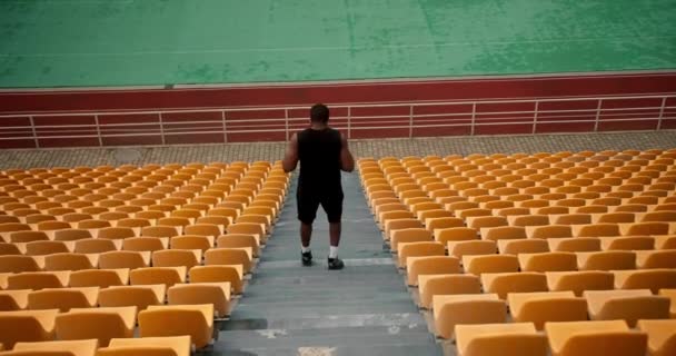 Sportlicher Mann Schwarzer Sportbekleidung Läuft Mit Gelben Stühlen Die Treppe — Stockvideo