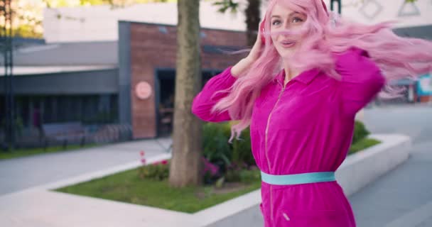 Happy Cheerful Girl Pink Red Wireless Headphones Jumps Street Listens — Stock Video