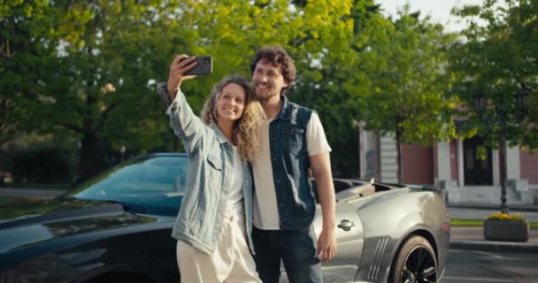 这对快乐的夫妇与他们的新灰色汽车合影 购买一个新的灰色可转换的 — 图库视频影像
