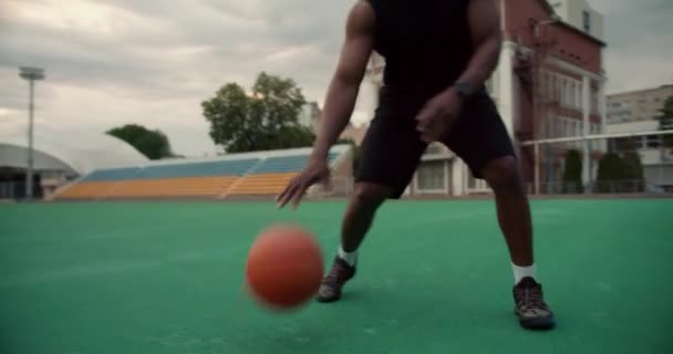 Szczelne Ujęcie Czarnoskórego Koszykarza Czarnej Odzieży Sportowej Uderzającego Piłkę Podłogi — Wideo stockowe