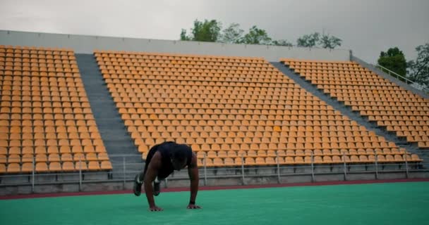 Навчання Спортивному Полі Чорношкірий Чоловік Чорному Спортивному Одязі Робить Вправи — стокове відео
