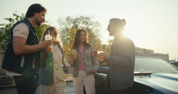 一群年轻时尚的人站在他们的车旁边玩乐 阳光明媚 阳光明媚 天气晴朗 — 图库视频影像