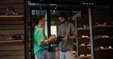 Man Businessman and woman in green t-shirt shoe designer communicate about new shoe collection at shoe factory. Business communication in the Loft style office.