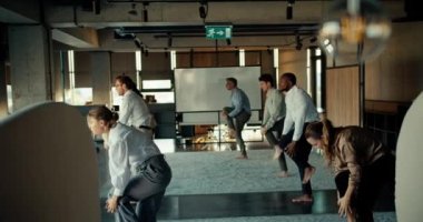 Ofisteki bir mola sırasında iş kıyafetleri içinde yoga yapan bir grup iş adamının genel değerlendirmesi. Kendine iyi bak, zamanını vücuduna ve ruhuna ayır..