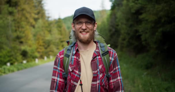 Blond Mężczyzna Turysta Brodą Okularach Czapce Stoi Czerwonej Koszuli Kratę — Wideo stockowe