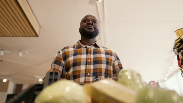 Снимок Снизу Человек Черным Цветом Кожи Прогулки Супермаркету Корзиной Выбирает — стоковое видео