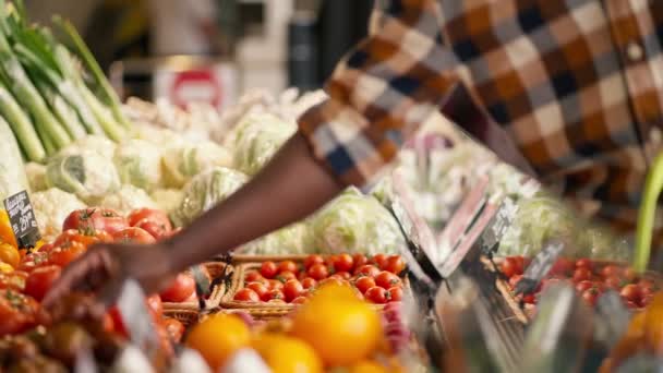 一名身穿格子花衬衫的黑人男子在超市柜台挑选蔬菜的特写镜头 观赏多汁 丰盛的夏季蔬菜 录像质量很高 — 图库视频影像