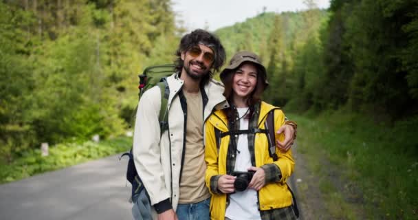 山林の背景にカメラを持ってハイキングするための特別な服の男と女の観光客 — ストック動画