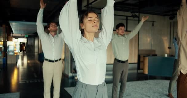 白いシャツを着たブロンドのビジネスガールは オフィスの同僚とヨガをしている スピリチュアルな強さと安定性を維持するために仕事から休憩を取る — ストック動画
