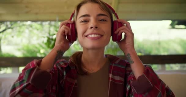 Ξανθιά Κοπέλα Κόκκινο Καρό Πουκάμισο Φοράει Κόκκινα Ασύρματα Ακουστικά Χαμογελάει — Αρχείο Βίντεο