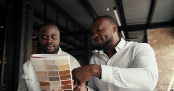 Двоє Чорношкірих Бізнесменів Білих Сорочках Обговорюють Колір Нового Взуття Офісі — стокове відео