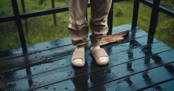 特写镜头 外面下雨天 一个穿着拖鞋的人站在黑暗板的地板上 — 图库视频影像