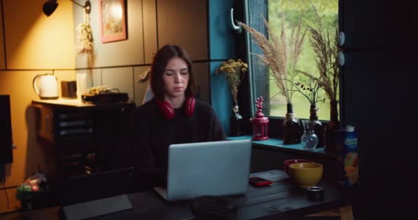 Una Chica Morena Con Auriculares Rojos Trabaja Portátil Una Habitación — Vídeo de stock
