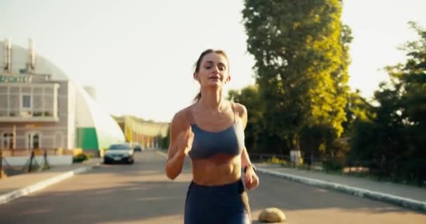 若いフィットガールは スポーツ夏の制服で通りをジョギングします 健康的なライフスタイルのためにスポーツをする — ストック動画