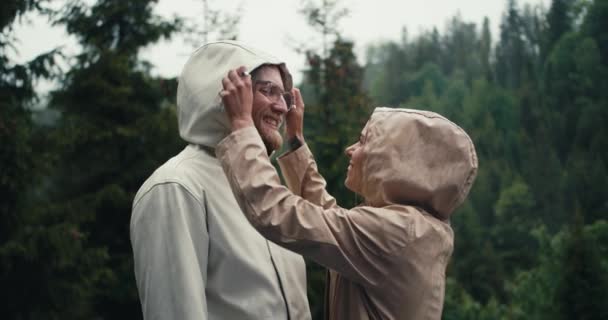 在雨中 一对快乐的夫妇 一男一女 在山林的背景下欢快地拥抱在一起 — 图库视频影像