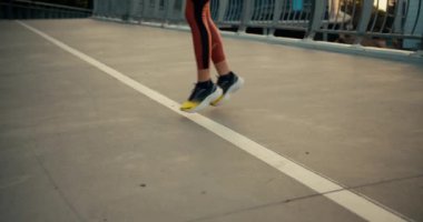 Spor üniformalı ve spor ayakkabılı bir kızın bir sabah koşusundan önce koşup ısındığı yakın plan bir fotoğraf..