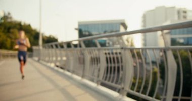 Mutlu hafif yorgun sporcu kız koşusu sırasında duraklıyor ve hareket etmeye devam ediyor. Sabah koşusu sırasında soluklan.