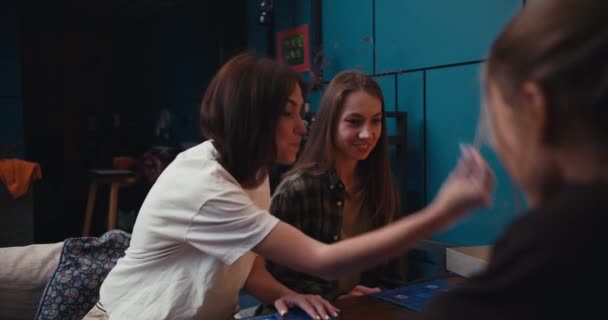 2人の幸せな女の子は ボードゲームでの勝利にとても満足しています 居心地の良い部屋で夜にボードゲームをする友人 — ストック動画