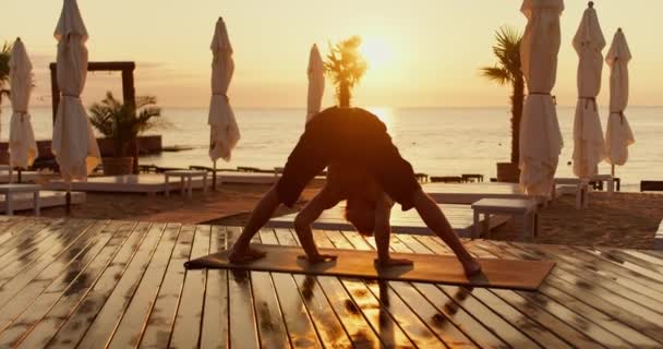 这家伙早上在海滩上做了一个特殊的瑜伽练习 头都抬了起来 清晨健康生活方式的瑜伽课 — 图库视频影像