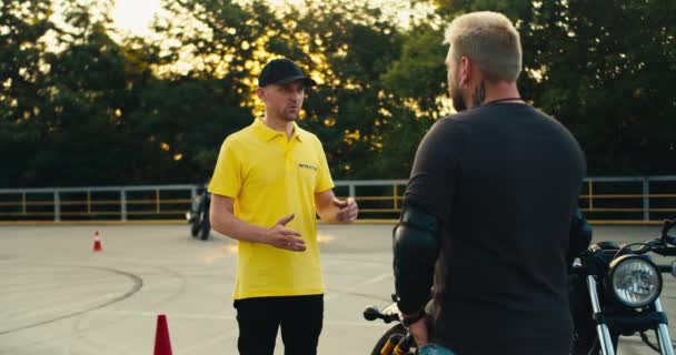 Ein Männlicher Instruktor Gelbem Shirt Und Mütze Erklärt Einem Biker — Stockvideo