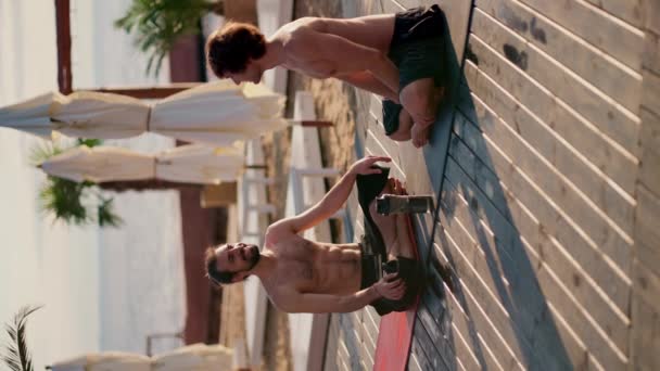 在阳光普照的海滩上 坐在冥想和交流位置上的2名瑜伽运动员的概述 — 图库视频影像