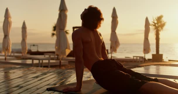 回顾一个家伙 他在瑜伽课上做了一个特殊的姿势 早上在阳光灿烂的海滩上沉思 — 图库视频影像