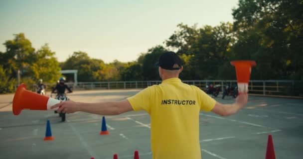 Ένας Δάσκαλος Οδήγησης Ένα Κίτρινο Shirt Δείχνει Έναν Μοτοσικλετιστή Προς — Αρχείο Βίντεο