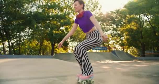 Dívka Krátkým Účesem Purpurovém Tričku Proužkovanými Kalhotami Sedí Létě Kolečkových — Stock video