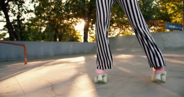 Крупный План Девушка Полосатых Штанах Едет Розовых Роликовых Коньках Скейт — стоковое видео