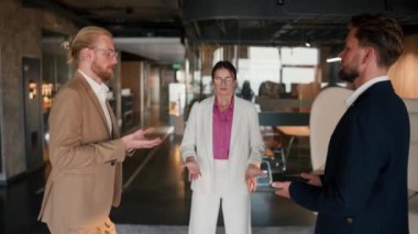 Ofis çalışanlarından oluşan bir takımda nefes alma teknikleri. Beyaz takım elbiseli ve pembe gömlekli bir kız, kahverengi ceketli bir adam ve modern bir ofiste mavi ceketli bir adam nefes alma teknikleri uyguluyor..