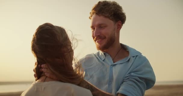 一个留着胡子 身穿蓝色衬衫的男人在外面刮风的时候把女朋友的头发弄得整整齐齐 黄昏时分的浪漫相遇 — 图库视频影像