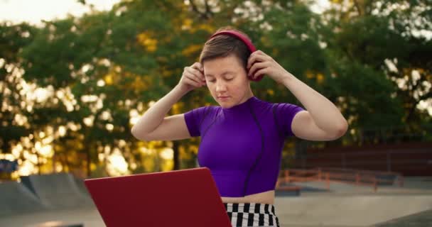 Młoda Krótkowłosa Dziewczyna Fioletowej Bluzce Zakłada Czerwone Słuchawki Rozpoczyna Pracę — Wideo stockowe